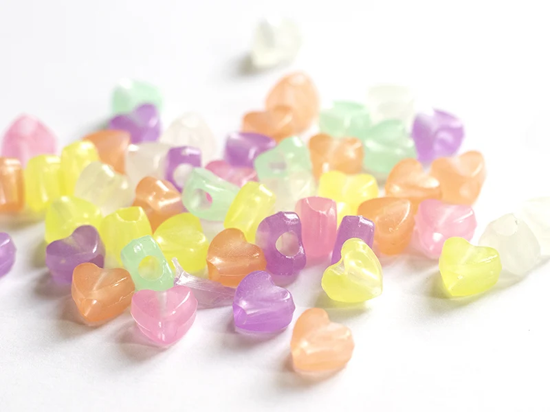 50 perles en plastique - cœurs - phosphorescent / brille dans le noir
