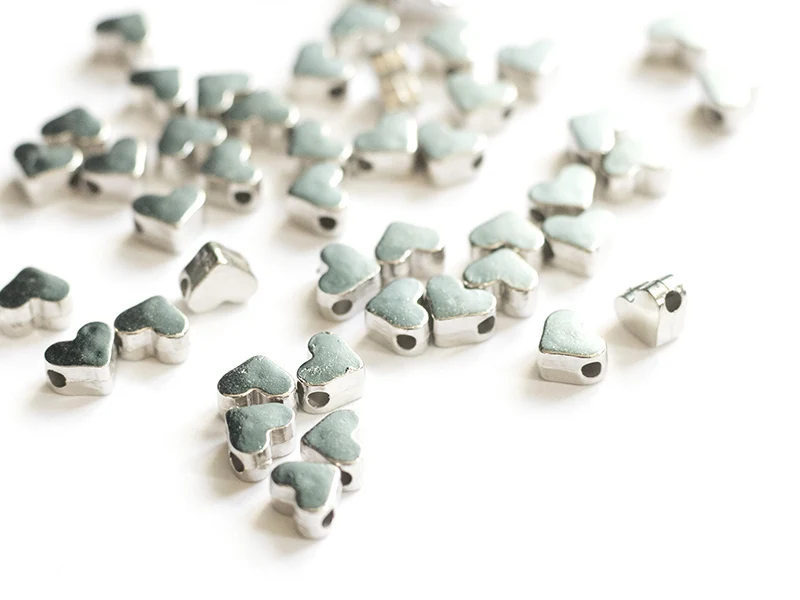 50 petites perles en plastique - cœurs argentés